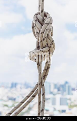 Corda bianca legata sulla barra di ferro sul tetto dell'edificio. Foto Stock