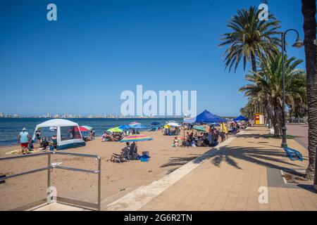 Sunbaters sulla spiaggia presso il Mar Menor a Mar de Cristal a Murcia, Spagna Foto Stock