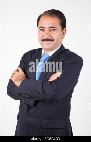 Amministratore delegato aziendale con baffi pieghevoli braccia dando una posa ritratto Foto Stock