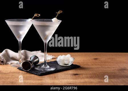 Gibson martini cocktail con cipolle su tavolo di legno Foto Stock