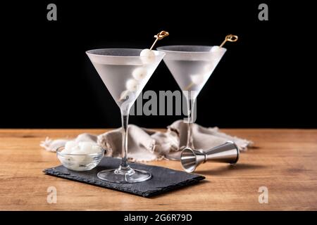 Gibson martini cocktail con cipolle su tavolo di legno Foto Stock