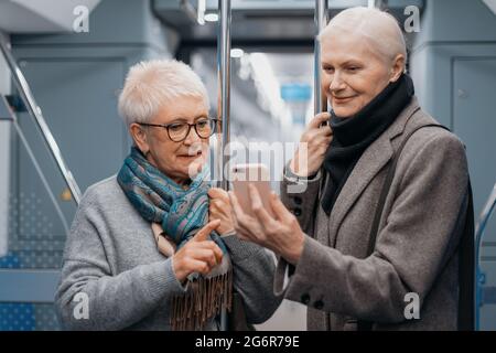 primo piano. due donne mature che usano uno smartphone in una macchina metropolitana. Foto Stock