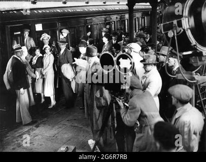 JOHN GIELGUD A. W. BASKCOMB MARY GLYNNE JESSIE MATTHEWS e DENNIS HOEY sul set location candid con la Film Crew nell'ottobre 1932 alla stazione ferroviaria di Willesden a Londra essendo diretto da VICTOR SAVILLE durante le riprese dei BUONI COMPAGNI 1933 regista VICTOR SAVILLE romanzo J.B. Priestley Gaumont British Film Corporation / Welsh-Pearson Foto Stock