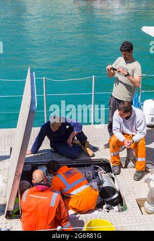 Uomini che lavorano a motore in barca a Padstow, Cornovaglia UK nel mese di giugno Foto Stock