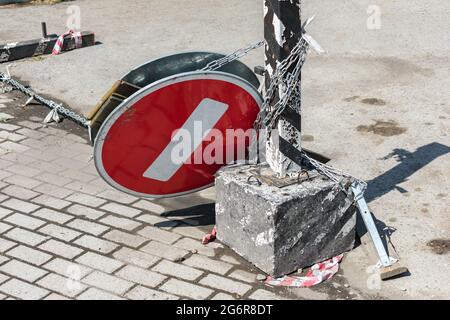 Un cartello stradale che indica un punto morto abbattuto in un parcheggio, appeso su un palo al quale è legato su una catena Foto Stock