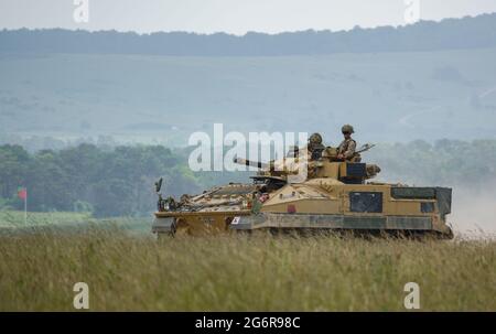 esercito britannico FV 510 Warrior veicolo da combattimento leggero fanteria e Land Rover Defender su manovre a Salisbury Plain, Wiltshire Foto Stock