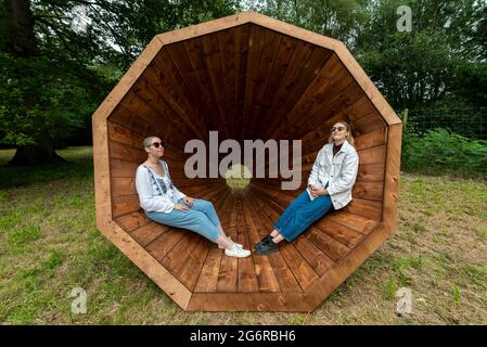 Aringly, Regno Unito. 8 giugno 2021. I membri del personale sperimentano 'RUUP: Forest Megaphones' di Birgit Olgus, uno dei tre giganteschi megafoni in legno. Anteprima di Summer of Sound dove sei impressionanti installazioni sonore su larga scala hanno riacquisto Wakehurst, il selvaggio giardino botanico di Kew in Sussex. Gli artisti hanno creato installazioni che offrono momenti di pausa e di sentirsi connessi alla natura attraverso una sinfonia di suoni creati o ispirati dal mondo naturale. L'estate del suono è aperta dal 9 luglio al 12 settembre 2021. Credit: Stephen Chung / Alamy Live News Foto Stock