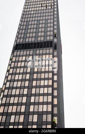 I lavoratori si abbisono per pulire le finestre e la facciata dell'edificio sudafricano ABSA banca ufficio a Città del Capo Foto Stock