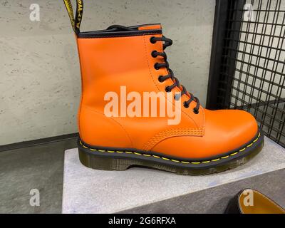 Roermond, Paesi Bassi - 1 lug. 2021: Primo piano di una singola scarpa di colore arancione nello scaffale del negozio dr Martens Foto Stock