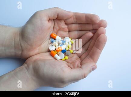 un sacco di pillole e compresse in mano, consumando un sacco di pillole concetto Foto Stock