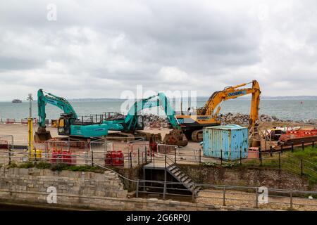 07-07-2021 Portsmouth, Hampshire, UK un escavatore e un mugnatore che lavorano sulle difese costiere a Southsea con il mare sullo sfondo Foto Stock