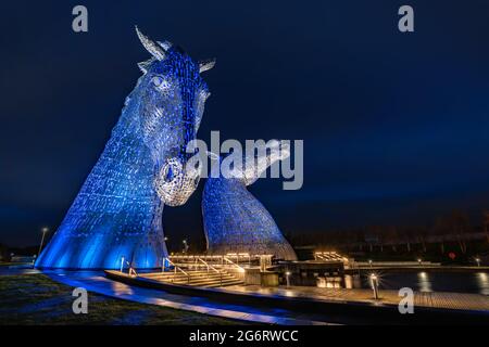 Una serata autunnale scura, bagnata e piovosa che fotografa le sculture di testa di cavallo in acciaio illuminate create da Andy Scott. Foto Stock