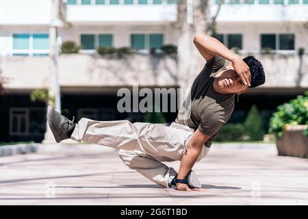 Giovane ispanico che fa la rottura-danza si muove nel parco e guardando la macchina fotografica. Foto Stock