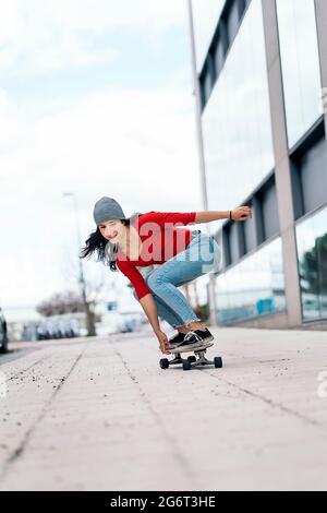 Giovane skater donna che pratica con il suo longboard in città e divertirsi. Foto Stock