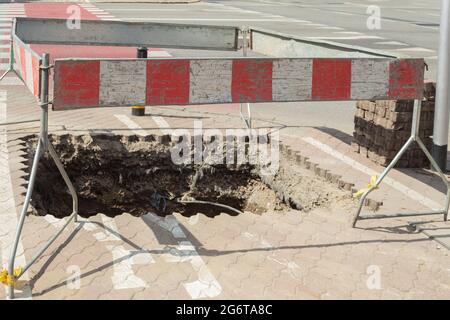 Recinzione di scavo. Barriere e recinzioni protettive durante i lavori di costruzione in città Foto Stock