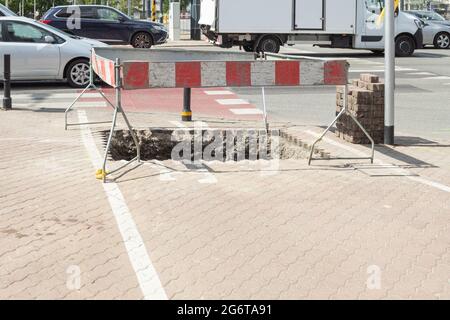 Recinzione di scavo. Barriere e recinzioni protettive durante i lavori di costruzione in città Foto Stock