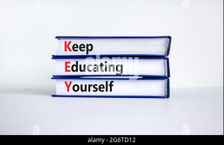 KEY, continuare a educare te stesso simbolo. Libri con parole 'CHIAVE, continuare a educare te'. Splendido sfondo bianco, spazio per la copia. Business, istruzione An Foto Stock