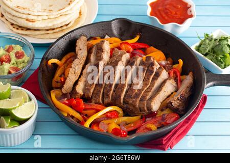 Fajitas di manzo con peperoni su un tavolo di legno blu brillante Foto Stock