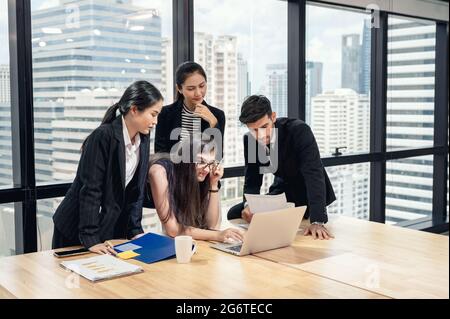 Team aziendale multietnico che si occupa di brainstorming e analisi di progetti aziendali in uffici moderni in centro Foto Stock