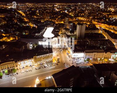 Kharkiv, Ucraina - 21 maggio 2021: Evento di apertura del centro commerciale Nikolsky. Luci notturne illuminate vista aerea della città sul tetto. Centro città vicino a Konstytutsi Foto Stock