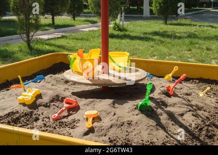 Sandbox in un asilo con giocattoli per giocare nella sabbia, con secchi, pale e muffe Foto Stock