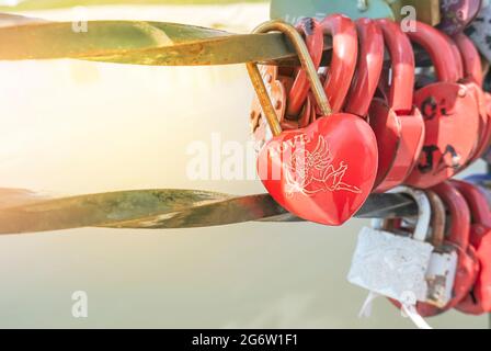 Un castello decorativo a forma di cuore sospeso pende sul ponte della città. Un simbolo di amore e lealtà eterni. Foto di alta qualità Foto Stock