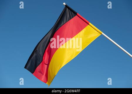 Bandiera della Germania su sfondo blu cielo. Foto Stock