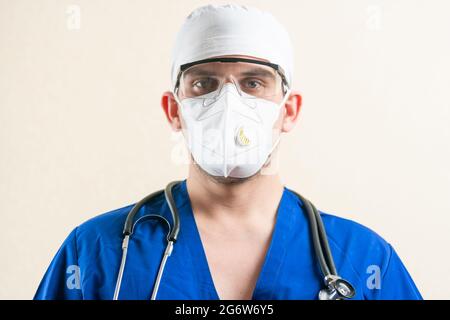 Medico in uniforme blu e maschera medica. Foto Stock