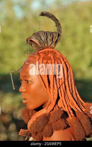 NAMIBIA. LA MEDICAZIONE DEI CAPELLI DELLE DONNE HIMBAS HA UN SIGNIFICATO SPECIALE. QUI, IL CAPPELLO IN PELLE DI CAPRA (EREMBE) SULLA SUA TESTA DICE CHE QUESTA DONNA È Foto Stock