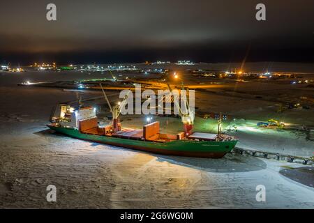 Sabetta, regione di Tyumen, Russia - 02 dicembre 2020: La nave da carico a secco è impegnata in operazioni di carico presso l'ormeggio. La nave è congelata nel ghiaccio. Foto Stock