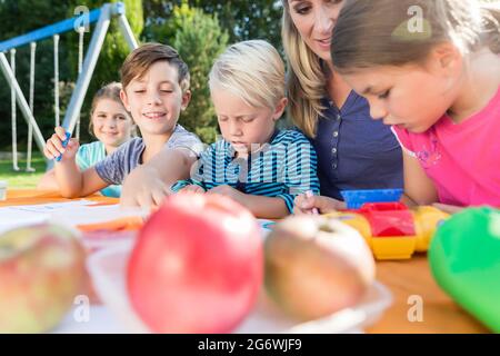 La mamma di pittura con le foto dei loro bambini e durante la pausa pranzo Foto Stock