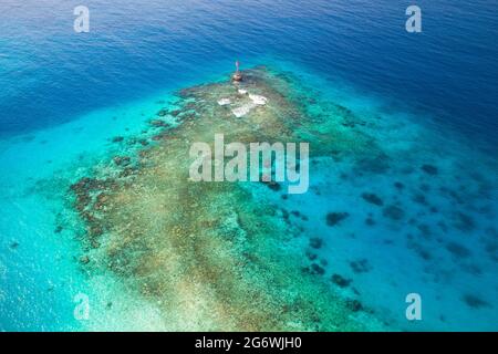 Acque poco profonde del Golfo Persico, Arabia Saudita. Il segnalatore luminoso rosso con il contrassegno triangolare superiore si trova su un fondo marino Foto Stock