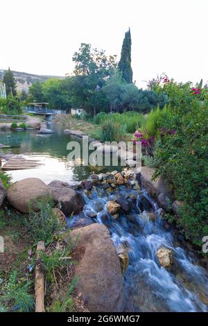 L'acqua limpida scorre nella piccola cascata della sorgente curda nel mezzo di Kiryat Shmona Foto Stock