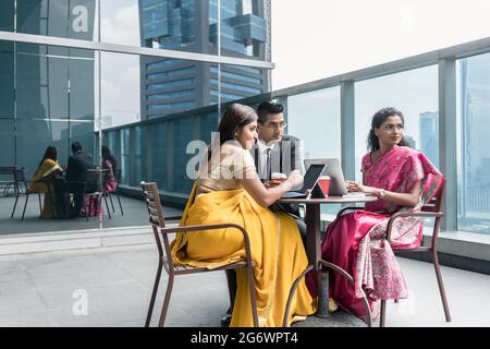 Tre Indian business persone con preoccupazione l'espressione del viso di parlare durante la pausa di lavoro Foto Stock