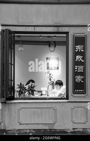 Una coppia di ristoranti visti attraverso una finestra al Ristorante Dongxin su Wukang Road nell'ex concessione Francese, Shanghai, Cina. Foto Stock