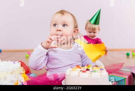 Toddler che mangia la torta di compleanno in asilo Foto Stock