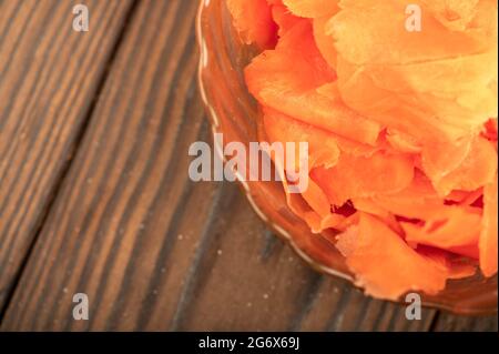 Zenzero decapato in un piatto di vetro su un tavolo di legno. Primo piano fuoco selettivo Foto Stock