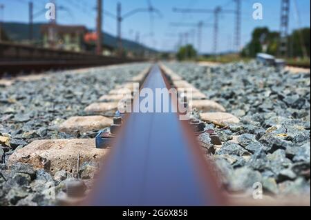 particolare di un binario ferroviario con i suoi fissaggi, traversine, zavorre, catenarie, ecc. Foto Stock