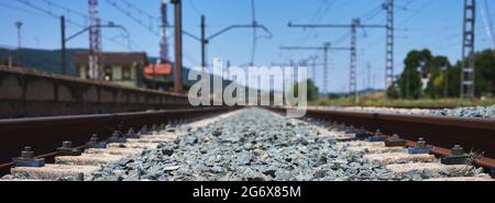 particolare di un binario ferroviario con i suoi fissaggi, traversine, zavorre, catenarie, ecc. Foto Stock