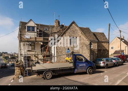 I lavoratori hanno messo in su gli scafoldings a cottage di Cotswold, Tetbury, Gloucestershire, regno unito Foto Stock