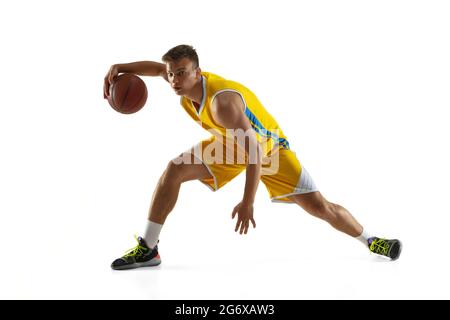 Un giovane, un giocatore di basket con un allenamento di palla isolato su sfondo bianco studio. Concetto di pubblicità. Atleta caucasico in forma dribbling Foto Stock