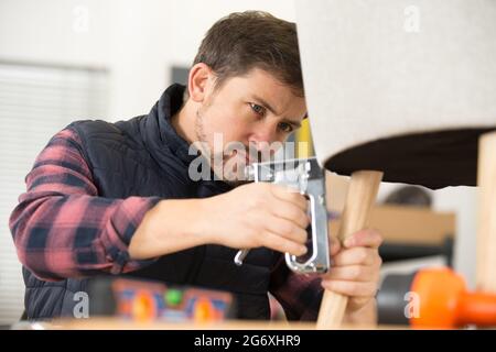 tappezzeria con una pistola per graffette Foto Stock