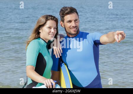 giovane coppia di bodyboard surfers che punta ad un'onda Foto Stock