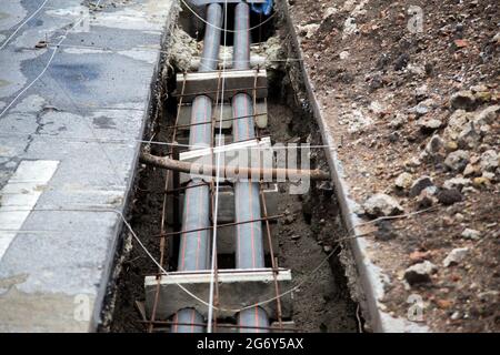 costruzione elettrica fibra sotterranea di strada con cemento blog in processo di costruzione della vita urbana nel sito Foto Stock