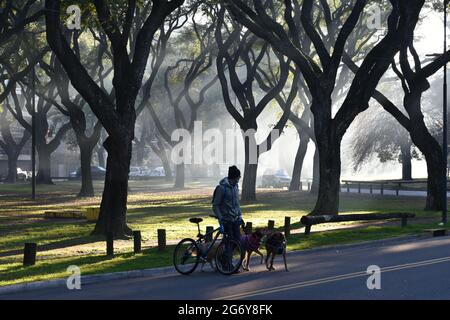 Buenos Aires, Argentina - 5 luglio 2021: Un cane seduto con la sua bicicletta in un parco di bosques del palermo foggy nel quartiere di Palermo Foto Stock