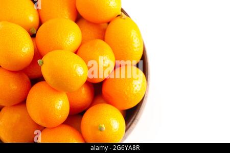 Una ciotola di Kumquat freschi isolato su uno sfondo bianco Foto Stock