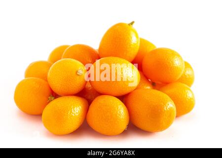 Un pile di Kumquat isolato su uno sfondo bianco Foto Stock