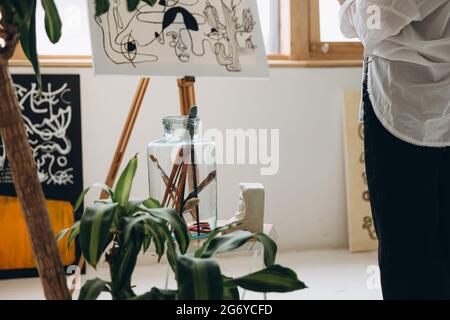 Primo piano di pittura giovane donna su cavalletto in studio d'arte Foto Stock