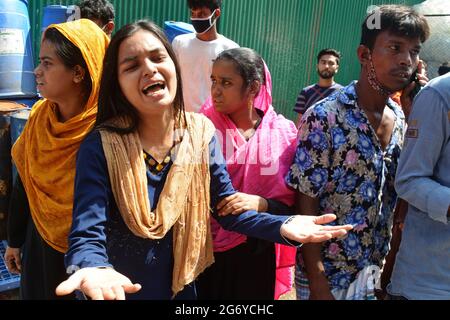 Dhaka, Bangladesh, il 9 luglio 2021.i parenti aspettano le loro persone scomparse dopo lo scoppio di un incendio nella fabbrica Hashem Foods Limited nel distretto di Narayanganj, alla periferia di Dhaka, Bangladesh, il 9 luglio 2021. La polizia ha detto che almeno 52 persone sono morte in un incendio scoppiato nella fabbrica di trasformazione alimentare durante la notte, mentre i vigili del fuoco continuano a combattere le fiamme nell'edificio a sei piani. Credit: Mamunur Rashid/Alamy Live News Foto Stock