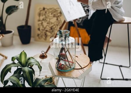 Primo piano del vaso di vetro con varie spazzole per la pittura Foto Stock